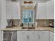 Modern kitchen with granite countertops, tile backsplash, stainless steel dishwasher and white cabinets at 18820 N 34Th Ln # 1, Phoenix, AZ 85027