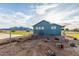View of backyard featuring desert landscaping, fire pit, a chain link fence, and mountain views in the distance at 18934 E Happy Rd, Queen Creek, AZ 85142
