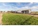 Grassy backyard between two detached homes that have brick retaining walls and mature trees at 18934 E Happy Rd, Queen Creek, AZ 85142