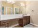 Bathroom features a wood vanity, a sit-down vanity area, a large mirror and modern lighting at 18934 E Happy Rd, Queen Creek, AZ 85142