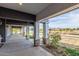 Spacious covered patio with architectural columns, stone accents, and outdoor ceiling fans at 18934 E Happy Rd, Queen Creek, AZ 85142