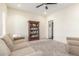 Living room featuring plush carpeting, a large sofa, and a dark wood bookcase at 18934 E Happy Rd, Queen Creek, AZ 85142