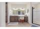 Bathroom featuring dual sinks, framed mirrors, and a glass-enclosed shower with a tiled floor at 18934 E Happy Rd, Queen Creek, AZ 85142