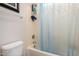 Close-up of a bathtub featuring a shower with a blue shower curtain and essential bath accessories, creating a functional space at 1916 E Dubois Ave, Gilbert, AZ 85298