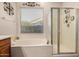 Bright bathroom featuring a soaking tub, glass enclosed shower, and decorative accents, providing a luxurious and relaxing space at 1916 E Dubois Ave, Gilbert, AZ 85298