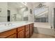 Bathroom with a double vanity, white countertops, soaking tub and decorative wall art at 1916 E Dubois Ave, Gilbert, AZ 85298