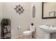 Powder room with a white sink, toilet, decorative wall art, and a tiled floor at 1916 E Dubois Ave, Gilbert, AZ 85298