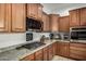Close-up of kitchen featuring granite countertops, stainless steel appliances and wooden cabinetry at 1916 E Dubois Ave, Gilbert, AZ 85298