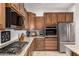Kitchen area showcasing stainless steel appliances, granite countertops and ample wooden cabinetry at 1916 E Dubois Ave, Gilbert, AZ 85298