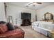 Bedroom with a leather sofa, ceiling fan, and a mounted television above fireplace at 1916 E Dubois Ave, Gilbert, AZ 85298