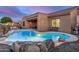 A sparkling pool with a rock waterfall is the centerpiece of this backyard, complemented by desert landscaping at 1916 E Dubois Ave, Gilbert, AZ 85298