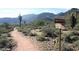 Desert landscape with a walking trail and cactus. A sign marks the direction of the trail at 19933 W Marshall Ave, Litchfield Park, AZ 85340