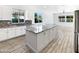 A modern kitchen with white cabinets, a gray backsplash, and a spacious island with a granite countertop at 20075 E Kestrel St, Queen Creek, AZ 85142