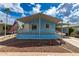 Charming single-story light blue home with a covered porch, landscaped front yard, and American flag at 201 S Greenfield Rd # 144, Mesa, AZ 85206