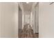 Bright hallway featuring wood-look flooring and white walls, leading to various rooms in the home at 201 S Greenfield Rd # 144, Mesa, AZ 85206