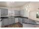 Well-lit kitchen featuring sleek countertops, modern appliances, stylish cabinets, and wood flooring at 201 S Greenfield Rd # 144, Mesa, AZ 85206