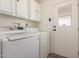 Clean laundry room with washer, dryer, overhead cabinets and an exterior door with a window at 201 S Greenfield Rd # 144, Mesa, AZ 85206