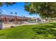 Expansive community pool with a stone deck, umbrellas, and plenty of lounge chairs at 201 S Greenfield Rd # 144, Mesa, AZ 85206