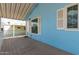 Covered porch with white trim with view to the yard, door and window of the light blue home at 201 S Greenfield Rd # 144, Mesa, AZ 85206