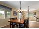 Open dining room featuring a wooden table set, chandelier, and natural light with views of the backyard at 2055 W Jasper Butte Dr, Queen Creek, AZ 85144