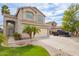 Charming two-story home featuring a well-maintained lawn, desert landscaping, and a convenient two-car garage at 2055 W Jasper Butte Dr, Queen Creek, AZ 85144