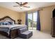Relaxing main bedroom features a comfortable king bed, balcony access, and ample natural light at 2055 W Jasper Butte Dr, Queen Creek, AZ 85144