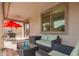 Cozy covered patio with comfortable seating, a red umbrella, and a view of the backyard at 2055 W Jasper Butte Dr, Queen Creek, AZ 85144