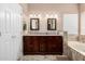 This bathroom offers a dual sink vanity with granite counters, tile backsplash, a tub, and decorative lighting at 2131 E New Bedford Dr, Gilbert, AZ 85234