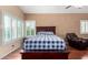 This primary bedroom offers neutral walls, wood floors, shuttered windows, and a seating area for a relaxing retreat at 2131 E New Bedford Dr, Gilbert, AZ 85234