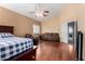 This bedroom offers neutral walls, wood floors, a ceiling fan and a seating area for a relaxing retreat at 2131 E New Bedford Dr, Gilbert, AZ 85234