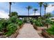 A lush community garden with vibrant plants, raised beds, and a shaded pergola at 2131 E New Bedford Dr, Gilbert, AZ 85234