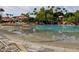 Community beach style pool featuring a sandy beach area, landscaping, and shade structures at 2131 E New Bedford Dr, Gilbert, AZ 85234