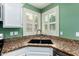 Close-up of the kitchen sink with green walls and shuttered windows at 2131 E New Bedford Dr, Gilbert, AZ 85234