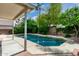 Beautiful backyard pool surrounded by lush tropical landscaping and a brick patio at 2131 E New Bedford Dr, Gilbert, AZ 85234