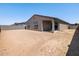 View of the home's exterior with a large backyard featuring partial fence and covered patio at 24493 W Grenadine Rd, Buckeye, AZ 85326