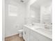 Bright bathroom featuring a double sink vanity, large mirror, natural light and white cabinets at 24493 W Grenadine Rd, Buckeye, AZ 85326