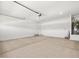 Clean two-car garage featuring neutral walls, lighting, and water heater at 24493 W Grenadine Rd, Buckeye, AZ 85326