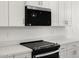 Close-up of the kitchen's modern appliances, white cabinets, and sleek countertops at 24493 W Grenadine Rd, Buckeye, AZ 85326