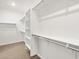 Walk-in closet with white built-in shelves and carpet at 24493 W Grenadine Rd, Buckeye, AZ 85326