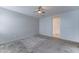 Carpeted bedroom with a ceiling fan and an access to an en suite bathroom at 25755 W Hazel Dr, Buckeye, AZ 85326