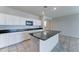 Open-concept kitchen featuring white cabinets, granite countertops, a center island, and views into the living area at 25755 W Hazel Dr, Buckeye, AZ 85326
