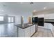 Open-concept kitchen featuring white cabinets, granite countertops, a center island, and views into the living area at 25755 W Hazel Dr, Buckeye, AZ 85326