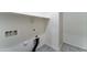 A laundry room features shelving, utility hook-ups, and tiled flooring at 25755 W Hazel Dr, Buckeye, AZ 85326
