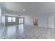 Spacious living room with tile flooring, ceiling fan and ample natural light from windows and sliding glass door at 25755 W Hazel Dr, Buckeye, AZ 85326