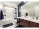 Well-lit bathroom featuring dark cabinets, white countertops, and a shower-tub combination at 2605 W Golden Puma Trl, Phoenix, AZ 85085