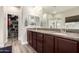 Bathroom featuring double sinks, granite countertops, dark cabinets, walk-in closet, and glass enclosed shower at 2605 W Golden Puma Trl, Phoenix, AZ 85085
