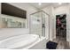 Bathroom with a soaking tub, a glass enclosed shower, and a walk-in closet with plenty of storage space at 2605 W Golden Puma Trl, Phoenix, AZ 85085