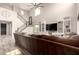 Bright living room with a large sofa, built-in shelving, and an elegant staircase at 2605 W Golden Puma Trl, Phoenix, AZ 85085