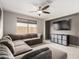 Carpeted living room area featuring a sectional sofa, ceiling fan, media console, and a large window at 2605 W Golden Puma Trl, Phoenix, AZ 85085