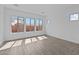 Bright bedroom featuring wood-look tile flooring, neutral paint, and large windows allowing ample natural light at 26079 S 228Th St, Queen Creek, AZ 85142
